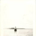 Catherine McDermott driving the boat and Belva Nelson surfboarding