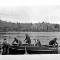 Art Pohlman landing boat, Axel Norlund standing, and Ed Smith sitting